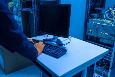 An operator using a computer beside network equipment in a server room