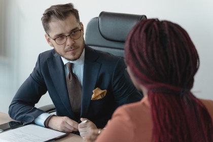 Two people discussing a document across a desk