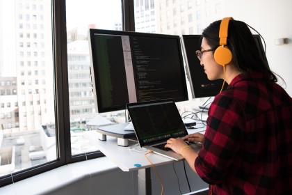 A developer working at a desk with several monitors